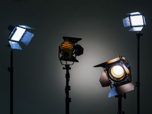 Dos reflectores con lámparas halógenas y lente fresnel y dos dispositivos de iluminación led. disparos en el interior sobre un fondo gris.